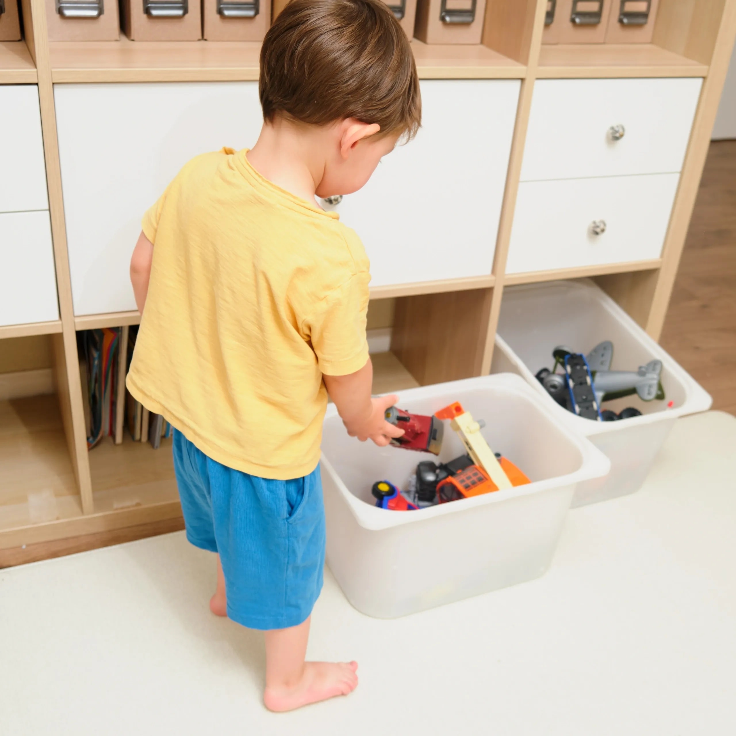 Organized colorful kids playroom with toy bins and shelves